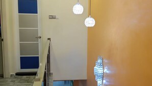 A hallway with a wooden floor, a blue door, and a staircase with a handrail. - The house is very strategic area. Nice and beautiful (Petaling Jaya)