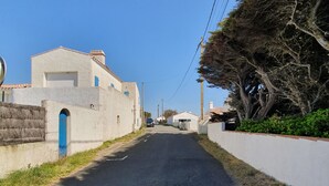 A narrow street flanked by buildings with white walls and blue doors, leading to a residential area. - 2 rooms apartment entirely renovated of 36 m2 (Noirmoutier-en-l'Île)