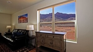 Una sala de estar con un ventanal que ofrece vistas a un paisaje desértico.