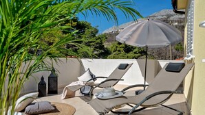 A rooftop terrace with two lounge chairs, a table, and a decorative umbrella. - Luxury Villa LeLu with heated saltwater pool suitable for children and pets, with parking, high speed Internet, BBQ (Žrnovnica)