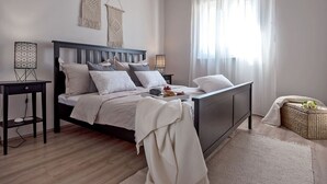 A neatly arranged bedroom with a bed, bedside tables, a bedside lamp, a bedside plant, and a woven basket. - Luxury Villa LeLu with heated saltwater pool suitable for children and pets, with parking, high speed Internet, BBQ (Žrnovnica)