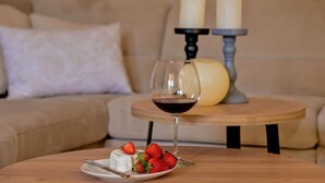 A cozy living room with a round wooden table, a glass of red wine, a plate of cheese and strawberries, and two candles on a stand. - Luxury Villa LeLu with heated saltwater pool suitable for children and pets, with parking, high speed Internet, BBQ (Žrnovnica)