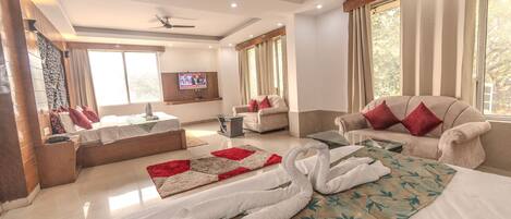 A spacious living area with a sofa, a coffee table, and a TV mounted on the wall.