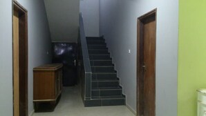 Un estrecho pasillo con una escalera que da a una distribución.