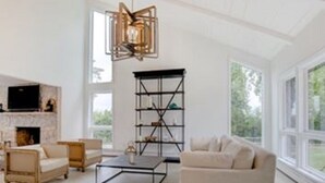 Un salón amplio con chimenea, un sofá, una mesa de centro y una estantería.