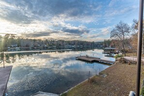 A calm lake with docks and boats, surrounded by trees and buildings. - Lake Sinclair Getaway + Rooftop Patio (Sparta)