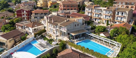 A residential area with multiple buildings, a swimming pool, and a view of distant mountains.
