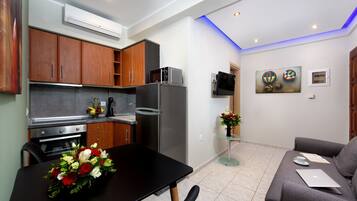 A modern kitchen with wooden cabinets, a refrigerator, and a dining table with a vase of flowers.