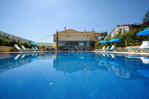 Relax by the pool surrounded by lounge chairs and umbrellas.