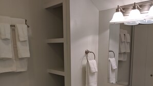 A bathroom with a toilet, a sink with a mirror, and a towel rack. - Lake Side Room at The Copper Trout. (Bayfield)