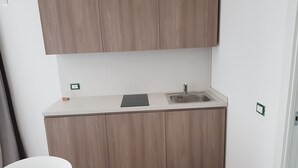 Una cocina compacta con un lavamanos, una encimera y armarios de madera.