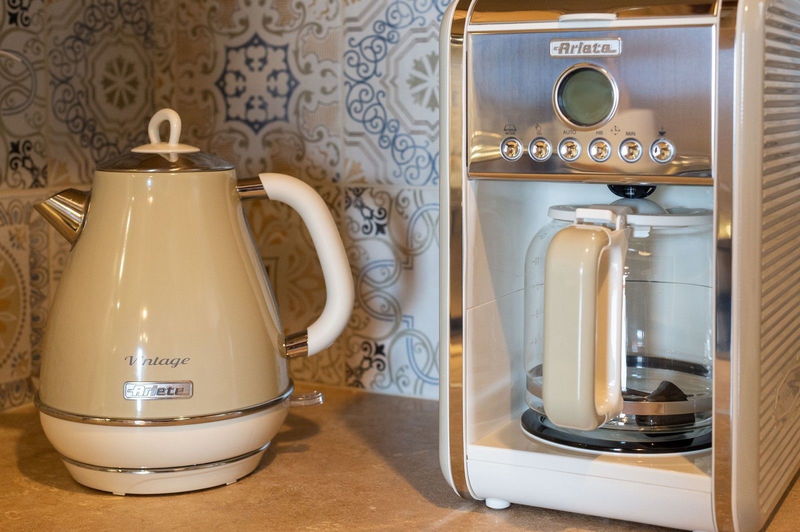 Una macchina da caffè in stile vintage, con una teiera e una macchina da caffè con display digitale e numerosi pulsanti.