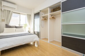 A bedroom with a bed, a wardrobe, and a window with curtains. - 50 Awesome Room! Great Location,Clean, (Osaka-shi)