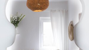 A white room with a bed, a wicker light fixture, a window with sheer curtains, and a wall-mounted decorative item. - Hotel Emeraude Essaouira (Essaouira)
