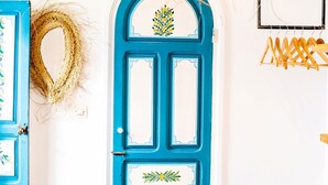 A blue door with decorative panels and a wreath on the wall. - Hotel Emeraude Essaouira (Essaouira)