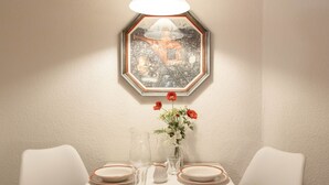 A dining table set with plates, glasses, and a vase with flowers. - Chalet Abendrot apARTments by Interhome (Grindelwald)