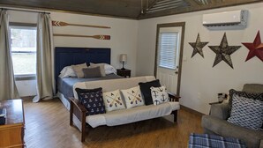 A bedroom with a bed, a bench, a wooden dresser, and a ceiling fan. - Welcome to Pearl Haven - a 500 sf gem! Hosting both Long and Short-term rentals! (Camden)