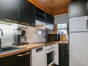 Een kleine keuken met een magnetron, koffiezetapparaat en een koelkast.