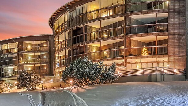 A modern building with multiple balconies and large windows, surrounded by snow. - Tahko spa junior suite orange b6 by Interhome (Nilsiä)