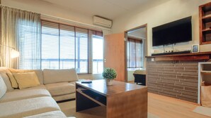 A modern living room with a sofa, a coffee table, a TV, and a fireplace. - Tahko spa junior suite orange b6 by Interhome (Nilsiä)