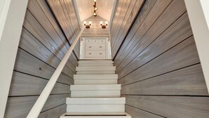 A staircase with wooden paneling and a light fixture at the top.