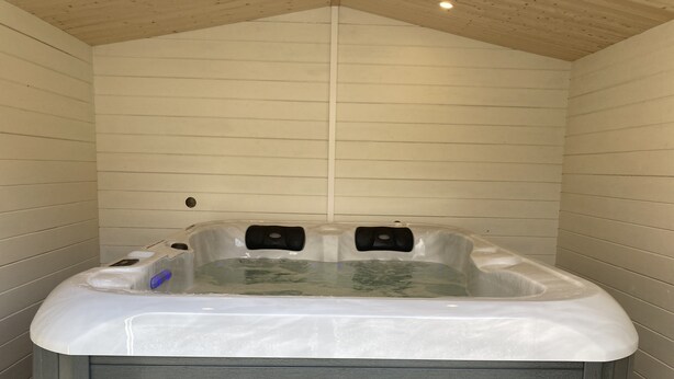 A hot tub in a room with wooden walls and a sloped ceiling. - THE HOUSE OF LAVOIR. (PLOUGUIEL)