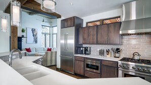 Una cocina moderna con electrodomésticos de acero inoxidable, armarios de madera y un amplio ventanal que proporciona luz natural.
