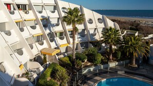 Een modern hotel met een uniek architectonisch ontwerp, inclusief ronde balkons en een zwembad.