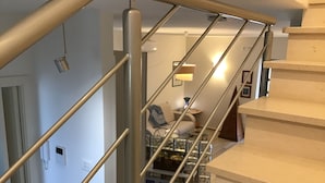 A staircase with a metal railing leading to a landing area.