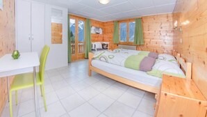 Habitación de cabaña de madera con cama, una mesita y una silla.