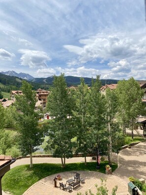 A residential area with houses, a paved courtyard, and a mountain backdrop.