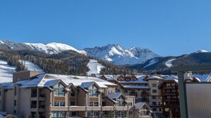 A resort with multiple buildings, snow-covered roofs, and mountains in the background. - Penthouse At The Peaks 751 (Mountain Village)