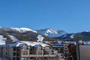 Un complexe hôtelier comprenant plusieurs bâtiments, des toits enneigés et des montagnes en arrière-plan.