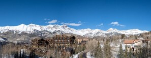 A lodge with multiple floors and a mountain backdrop.
