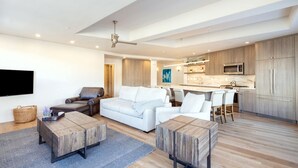 A modern living room with a sofa, coffee table, and a TV mounted on the wall. - Penthouse At The Peaks 751 (Mountain Village)