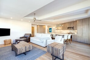 Un salon moderne avec un canapé, une table basse et un téléviseur fixé au mur.
