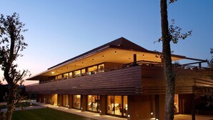 Un edificio moderno con techo plano, ventanas amplias y un espacio exterior cubierto.