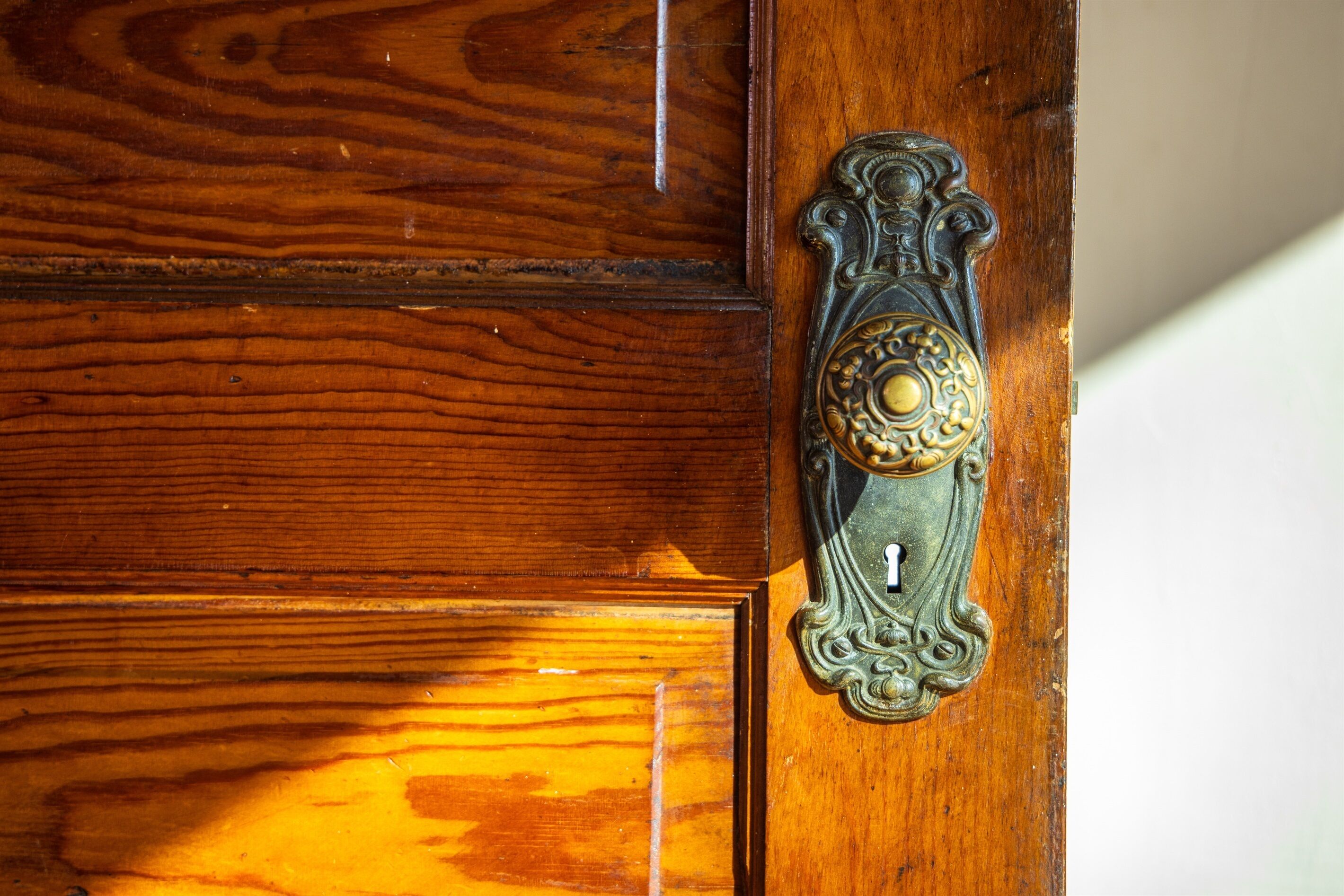 A wooden door with a brass door knocker and a number "1" on it.