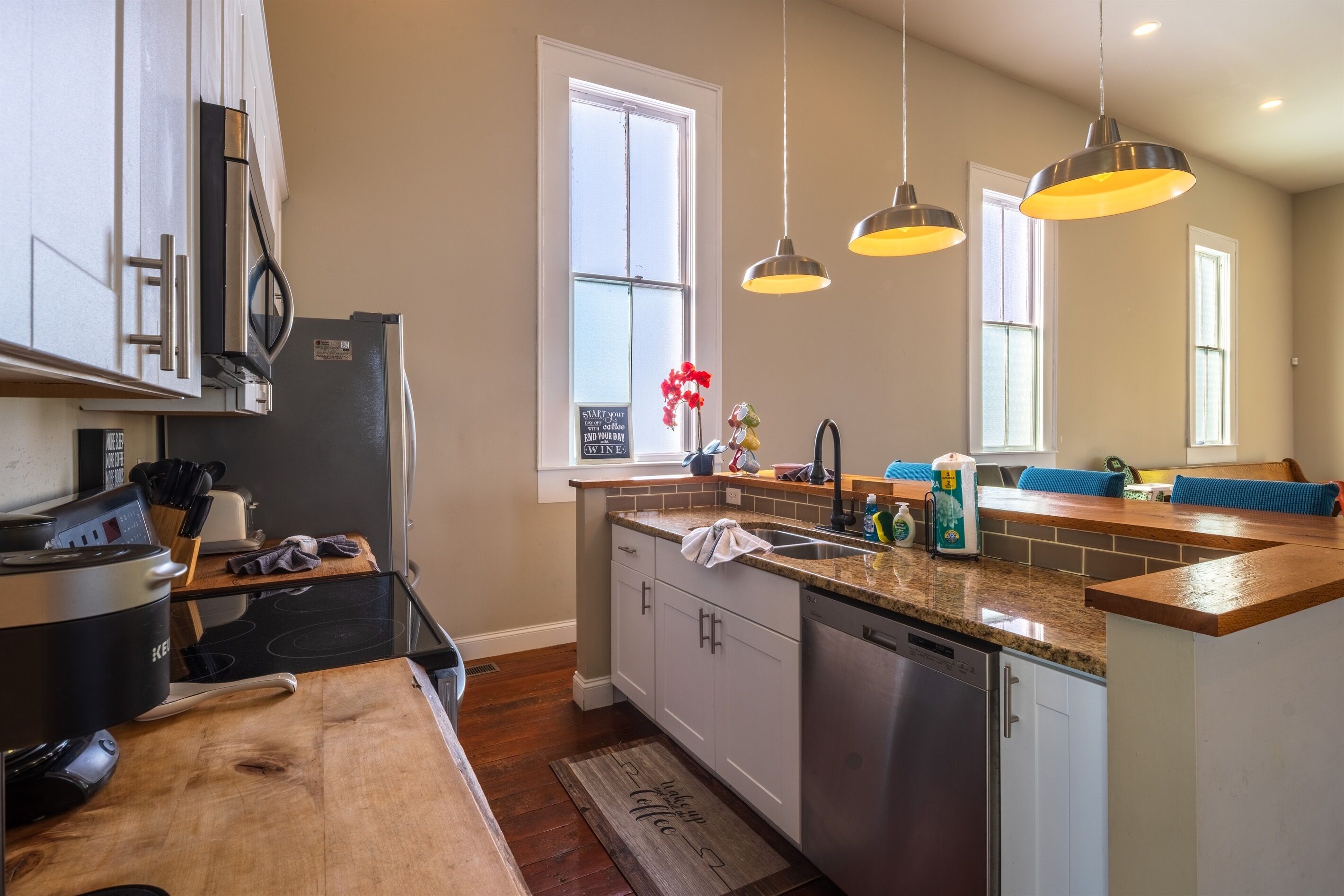 A modern kitchen with a central island, stainless steel appliances, and pendant lighting.