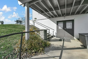 Guests enter through a covered entrance area, ascending a staircase to a door with a window.