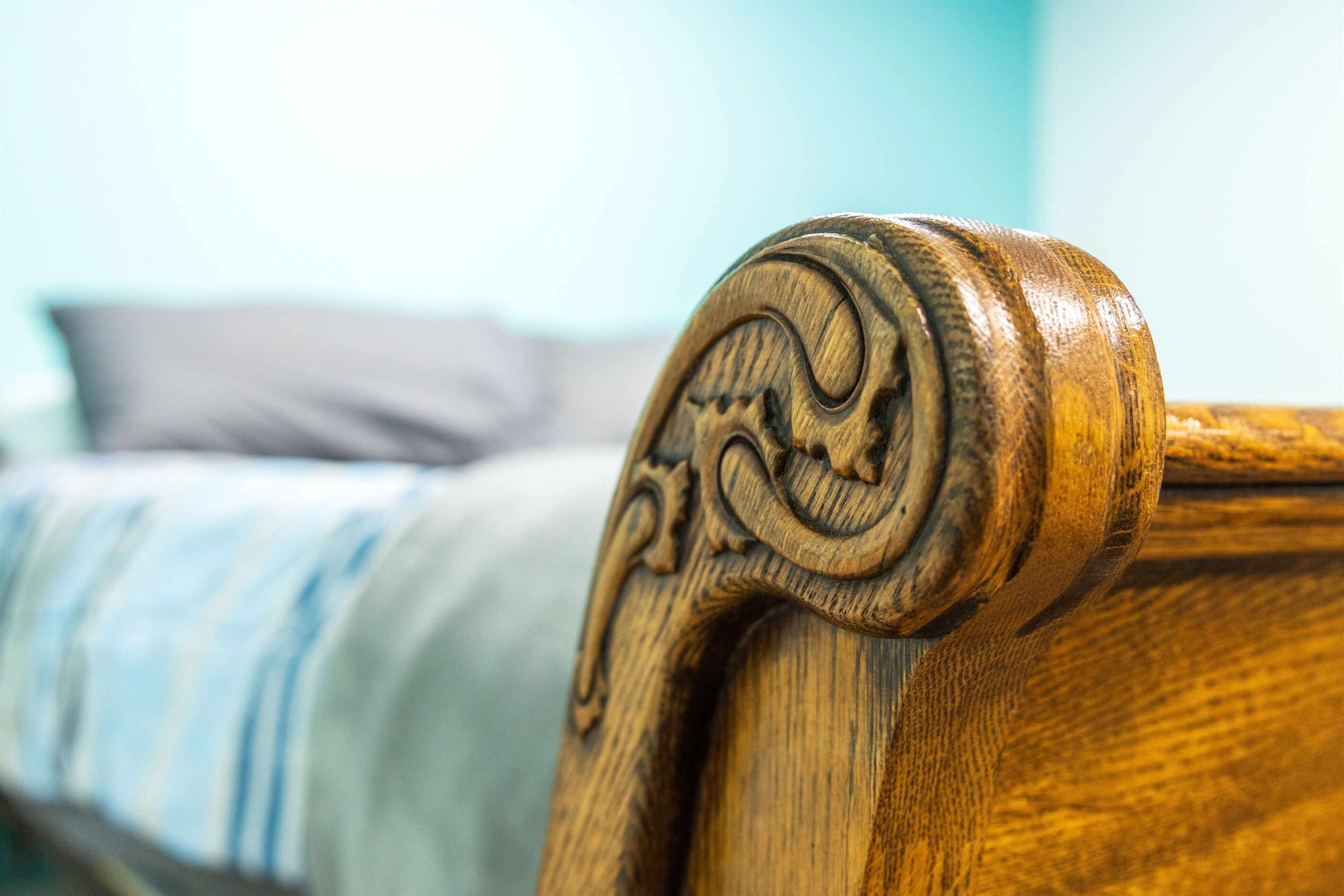 Un gros plan d’une tête de lit en bois ornée de sculptures complexes.
