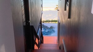 Vista da un corridoio su una zona piscina con una visuale aperta sul mare.