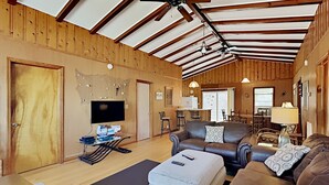 Una sala de estar acogedora con chimenea, televisor y comedor con mesa y sillas.