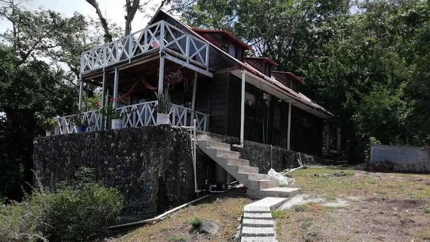 Ein rustikales Holzhaus mit einer Steintreppe, die zu einer Veranda führt.