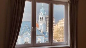 A window with a view of a blue building with a clock tower. - Heart of Bratislava-Blue Church views-Sleeps 5-6. (Bratislava)