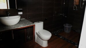 Un baño con lavamanos, inodoro y ducha blancos.