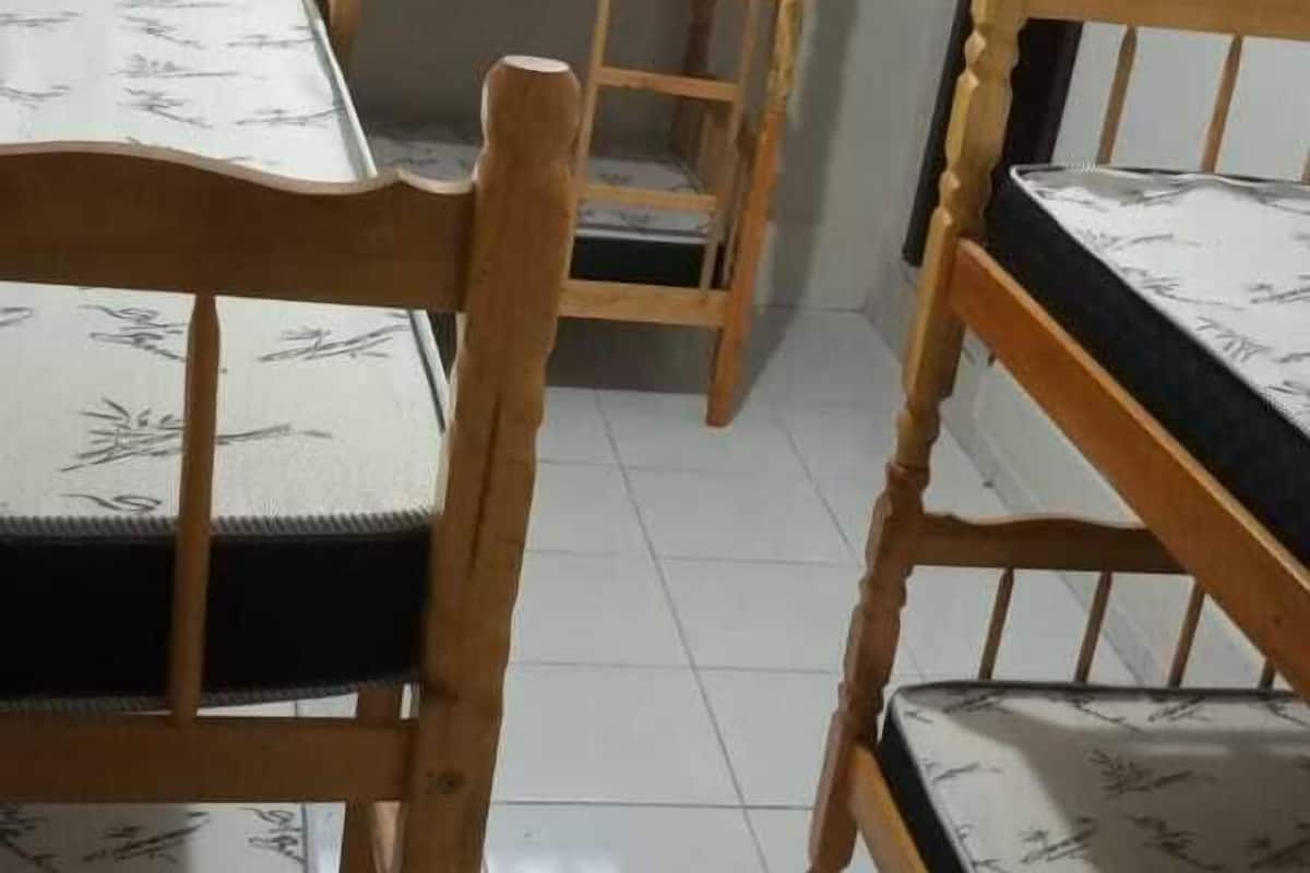 Une chambre de dortoir avec des lits superposés et une fenêtre donnant sur un paysage urbain.