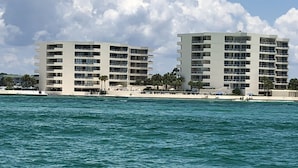 Ein Hotel direkt am Strand mit mehreren Etagen, Balkonen und einem Poolbereich.