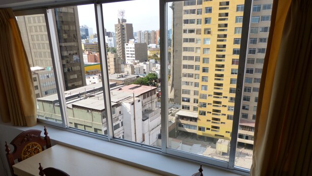 Una habitación con un ventanal que da a una vista panorámica de la ciudad.