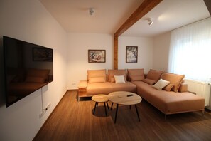 独特公寓 | 起居区 | 55-英寸纯平电视 （配备有线频道）、智能电视